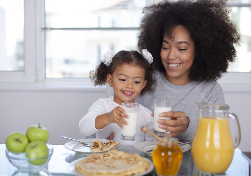 young mother and daughter having breakfast